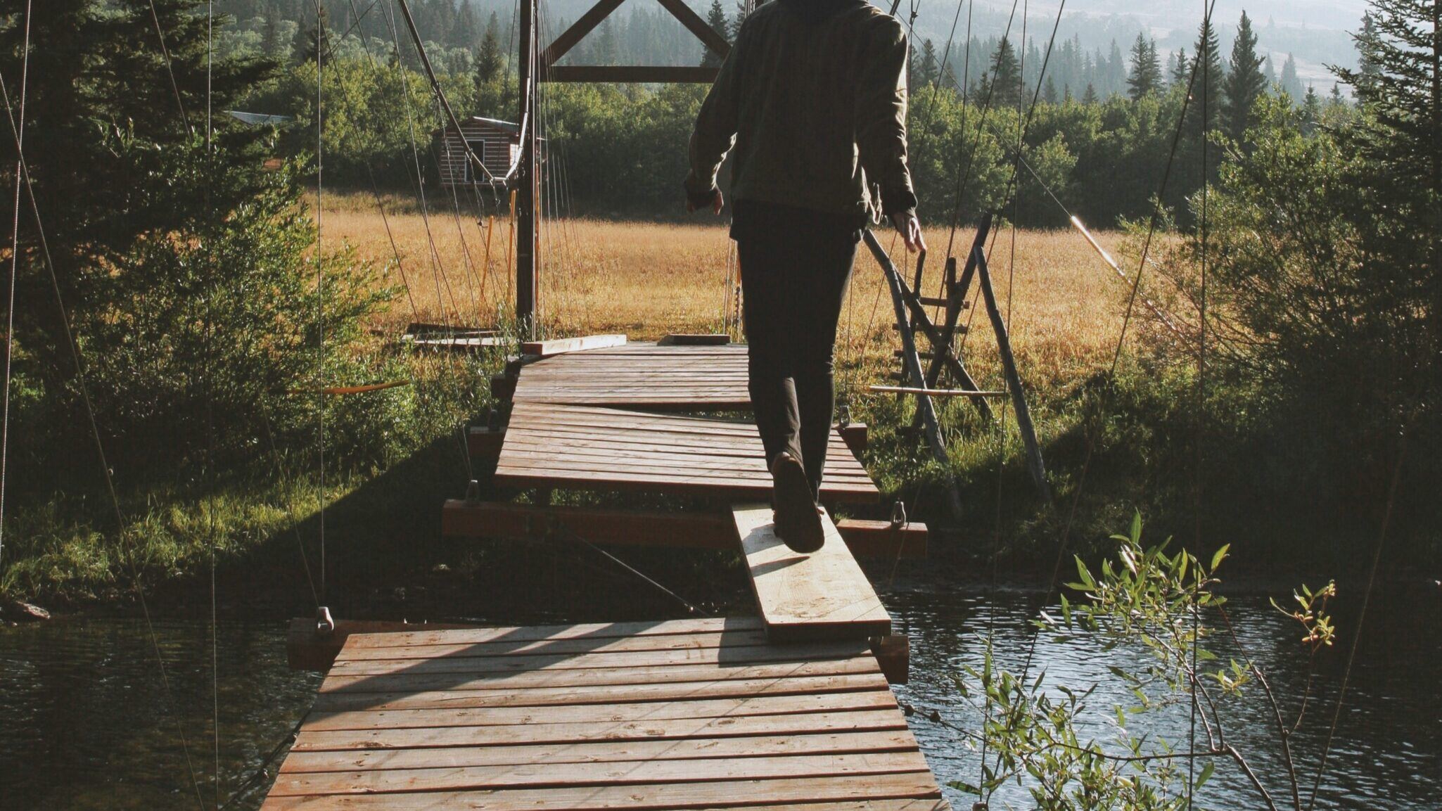 man-crossing-plank-bridge_16-9-scaled