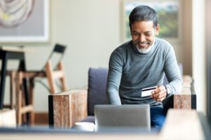 Attractive bearded hipster asian father or Hispanic old man using Laptop and credit card payment shopping online with customer network connection via omni channel system. Older man with technology.